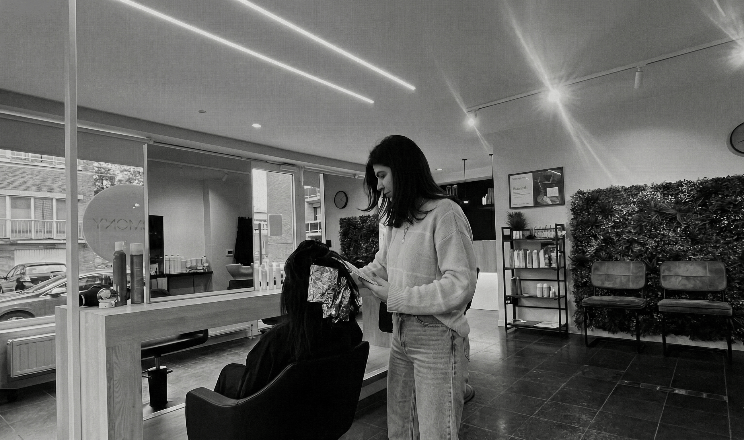 Kapster brengt kleurfolies aan bij een klant in het salon